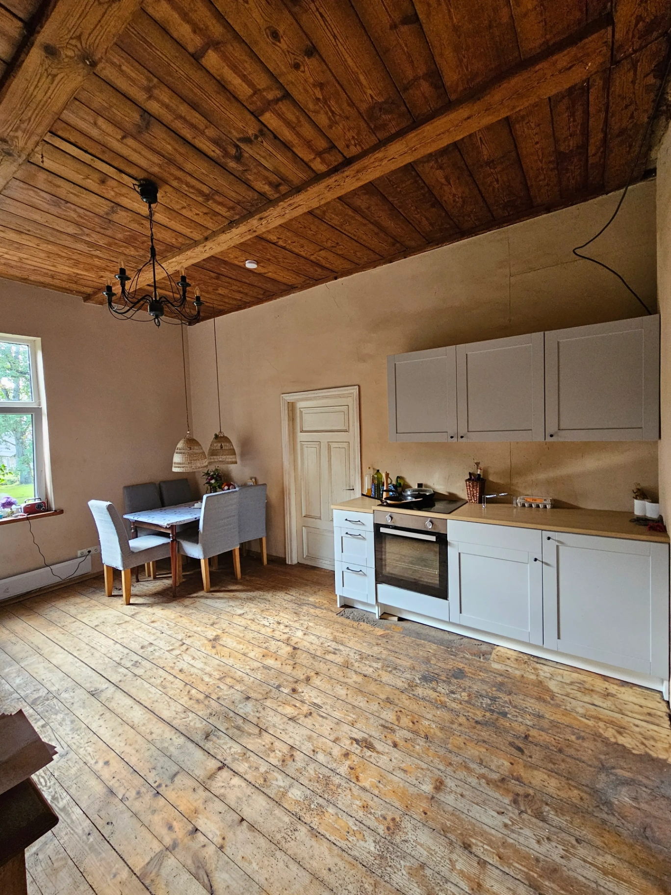 Kitchen with wooden ceiling beams, modern appliances and dining area